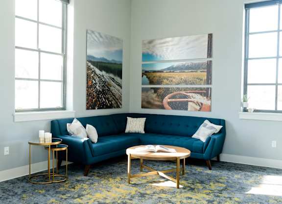 a living room with a blue couch and pictures on the wall