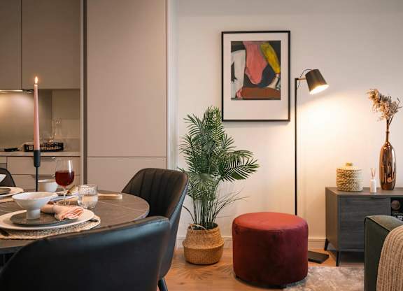 A dining room with a table set for two, a potted plant, and a framed artwork on the wall at Cherrywood Apartments, D18 VY3V, DUBLIN 18