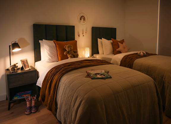 A cozy bedroom with two beds and a nightstand with a lamp at Cherrywood Apartments, D18 VY3V, DUBLIN 18