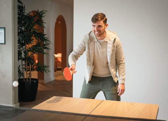 A man is playing ping pong in a room at Cherrywood Apartments, D18 VY3V, DUBLIN 18