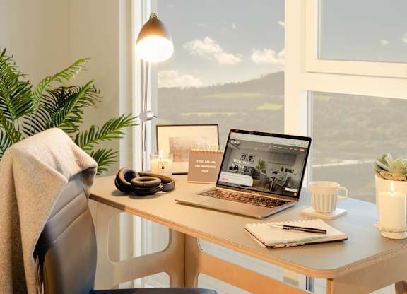 A laptop on a desk with a view of the countryside through the window at Cherrywood Apartments, D18 VY3V