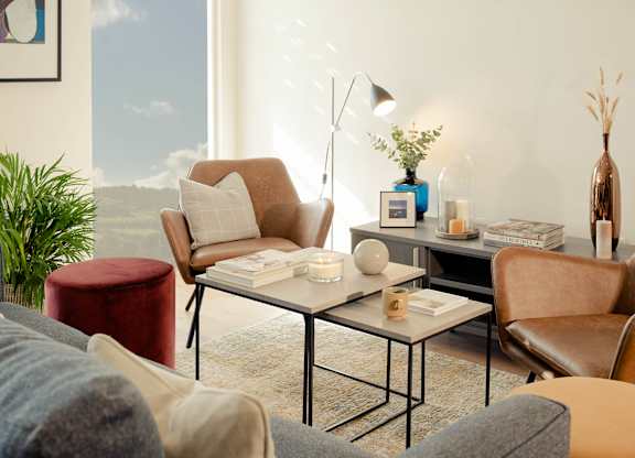 A living room with a large window, a sofa, a chair, a coffee table, and a lamp at Cherrywood Apartments, D18 VY3V