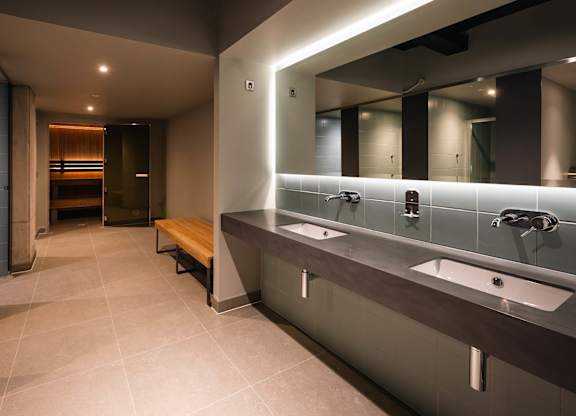 A bathroom with two sinks and a bench at Cherrywood Apartments, D18 VY3V
