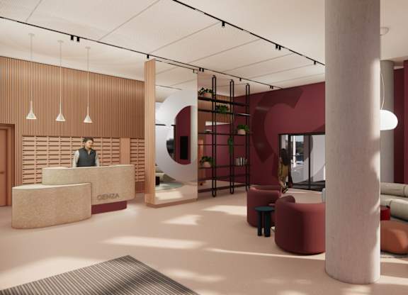 A reception area with a woman standing behind a desk.