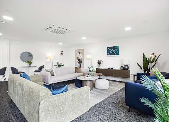 A living room with a white couch and a blue chair.