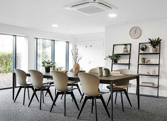 A dining room with a table and chairs.