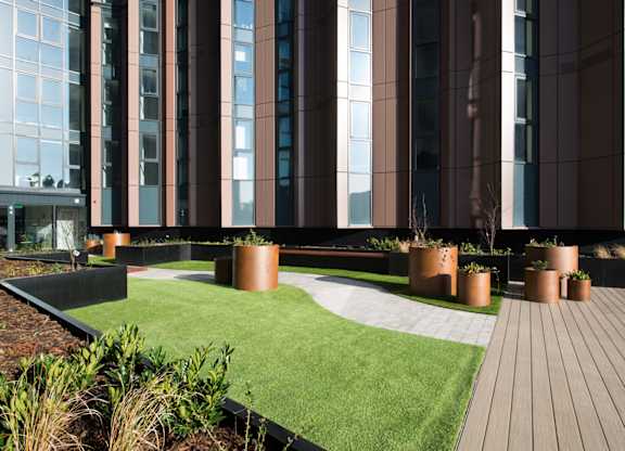 A modern building with a green lawn in front.
