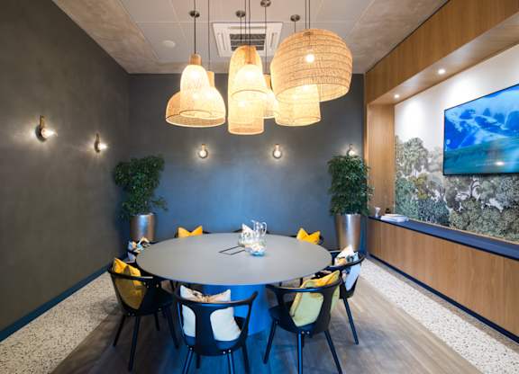 A conference room with a round table and chairs.