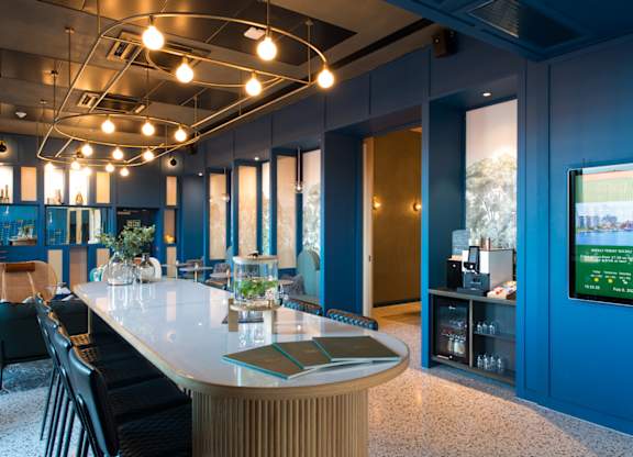 A modern room with a long table and chairs.