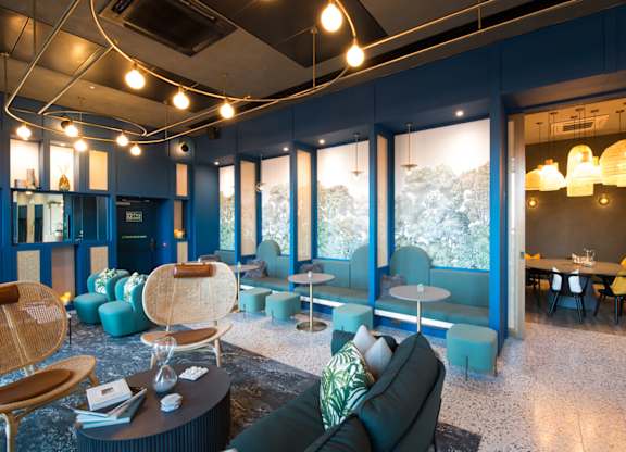 A modern living room with a blue accent wall and a variety of seating options.