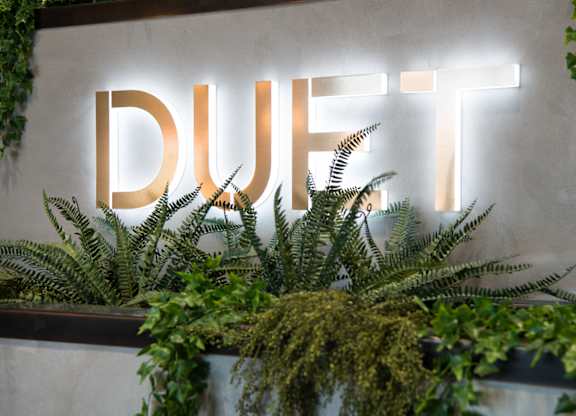A wall with a sign that says DUFT with plants in front of it.