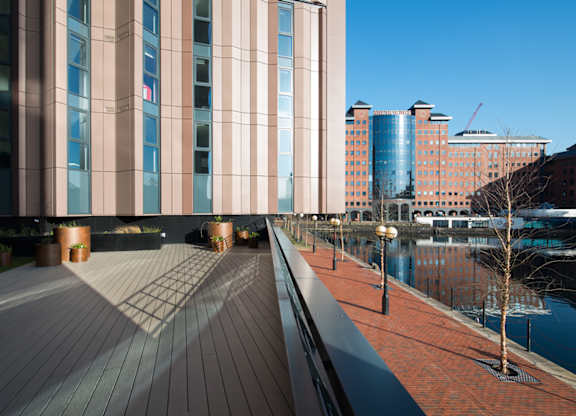 A long building with a lot of windows is next to a body of water.