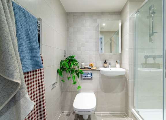 A bathroom with a toilet, sink, and shower.