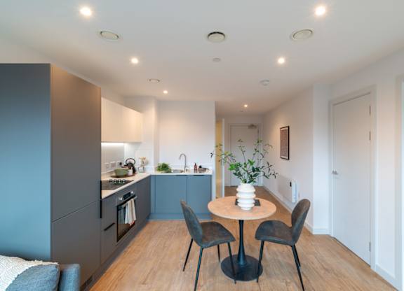 A modern kitchen with a dining table and chairs.