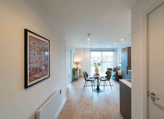 A living room with a table and chairs in the middle of the room.
