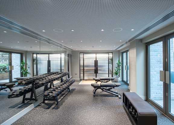 Spacious Gym with row of benches at The Lark, London