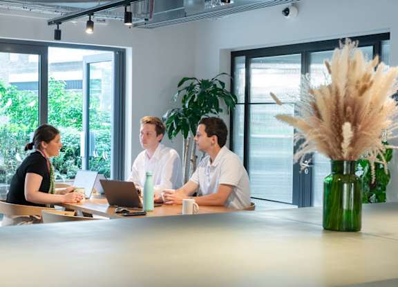 Three people sitting at a table in conference room at The Lark, London