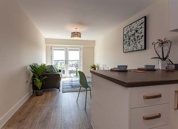 A kitchen with a white counter and a green chair.