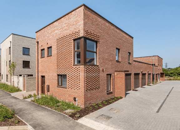 A long brick building with a large window on the side at Origins Apartments, Cambridge