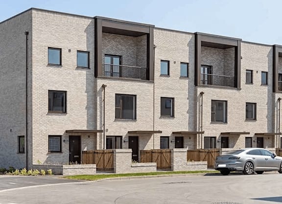 A modern apartment building with a car parked in front at Origins Apartments, Cambridge, CB3 0UX