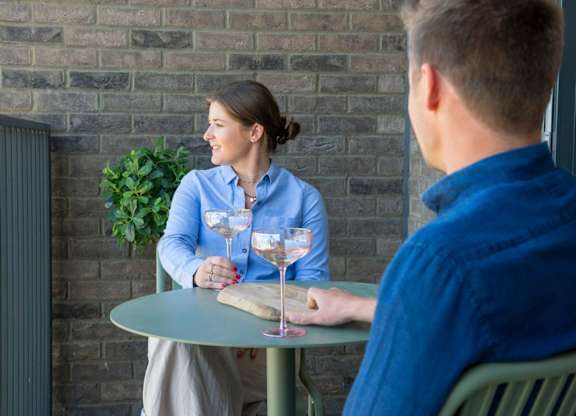 Man and a woman are sitting at a table with drinks at The Lark, London, SW11 7EA