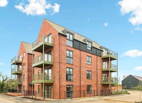 A red brick building with balconies on the second floor.