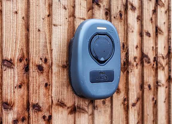 A blue device with the letters BG SYNC on it is mounted on a wooden wall at The Woodlands Apartments, Milton Keynes