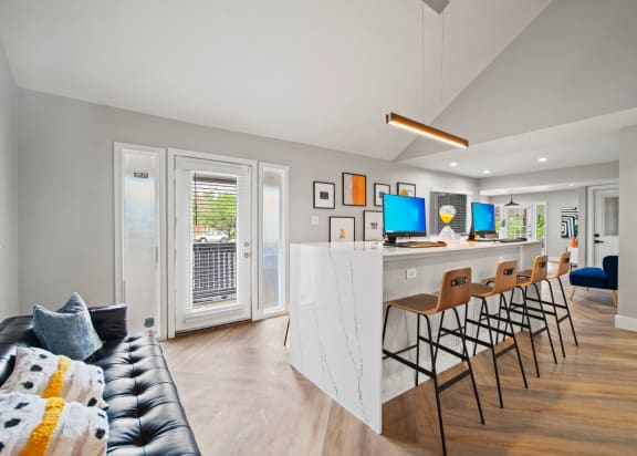 a living room with a bar and a kitchen with chairs