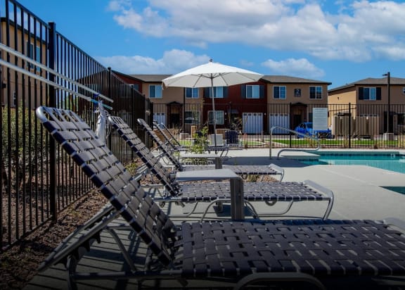 our apartments have a large pool with lounge chairs and an umbrella
