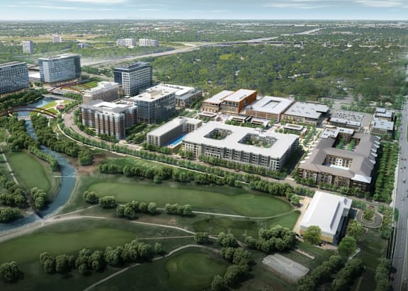 A bird's eye view of a campus with buildings and a river.