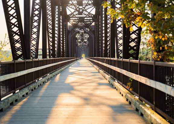 A bridge with a wooden walkway and metal trusses.