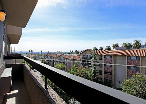 A balcony overlooks a row of apartment buildings.