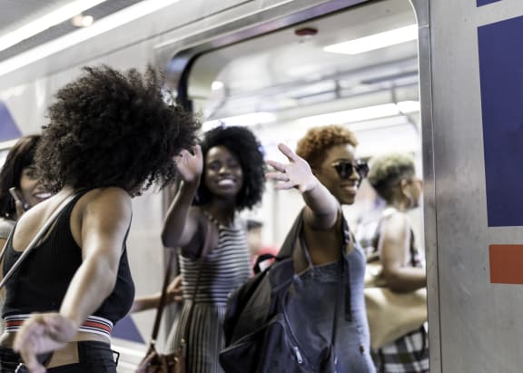 a group of women standing on a subway trainat Villages at Morgan Metro, Landover