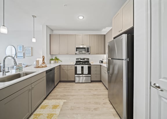 a large kitchen with stainless steel appliances and wooden floors