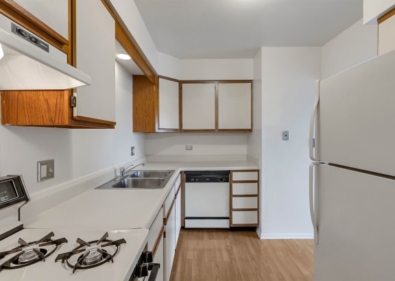 a kitchen with white countertops and wooden cabinets