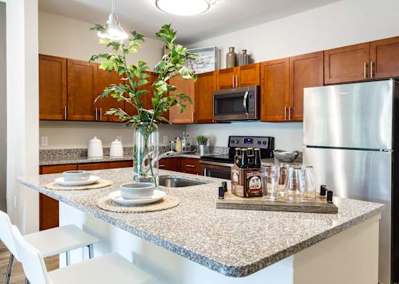 A kitchen with a granite countertop and a white chair.