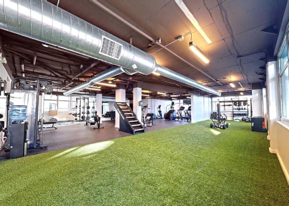 an indoor gym with a green carpet and a large window