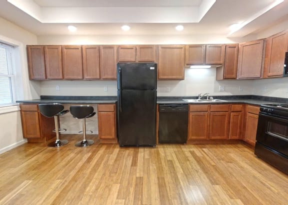 a kitchen with wooden floors and black appliances