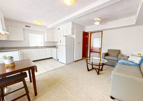 a living room and kitchen with a couch and a table