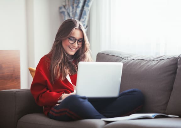 a woman sitting on a couch with a laptop