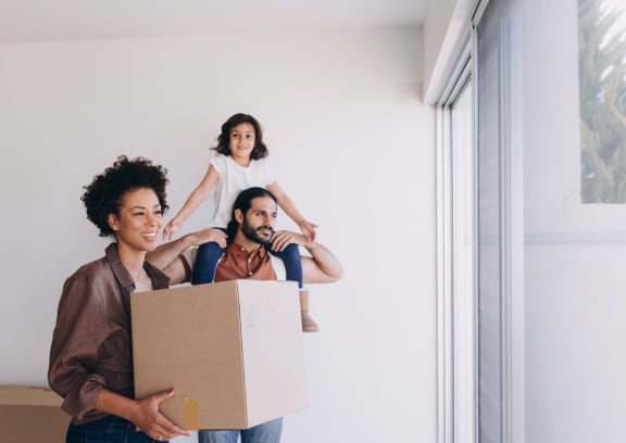 a man carrying a box with a woman and a girl holding a box