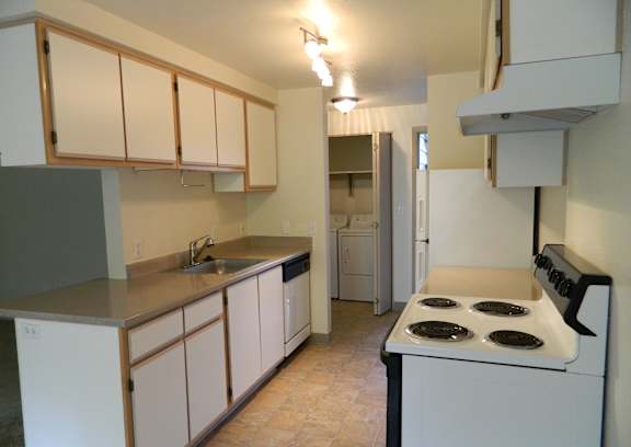 A kitchen with white appliances and cabinets.