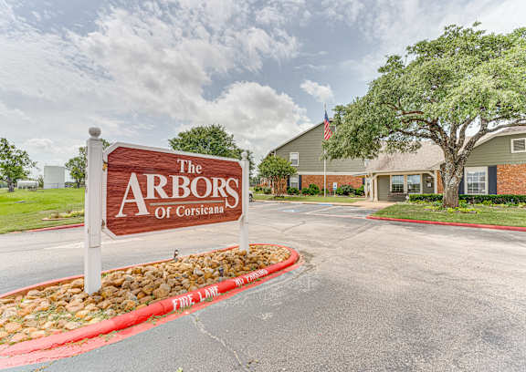 The Arbors of Corsicana sign in front of a building.
