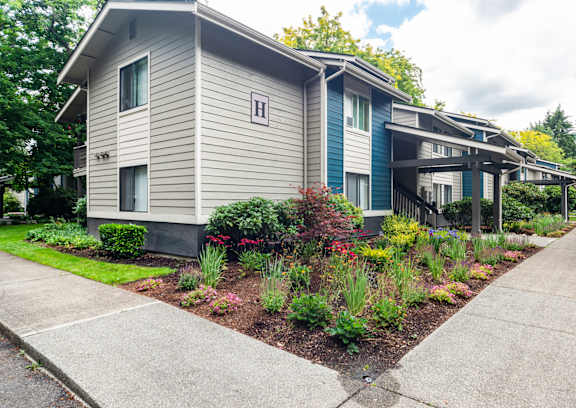 A row of houses with a sidewalk in front.