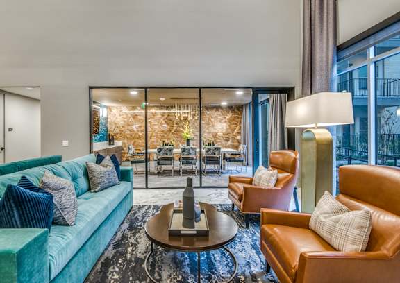 A living room with a blue couch, brown armchairs, and a coffee table.