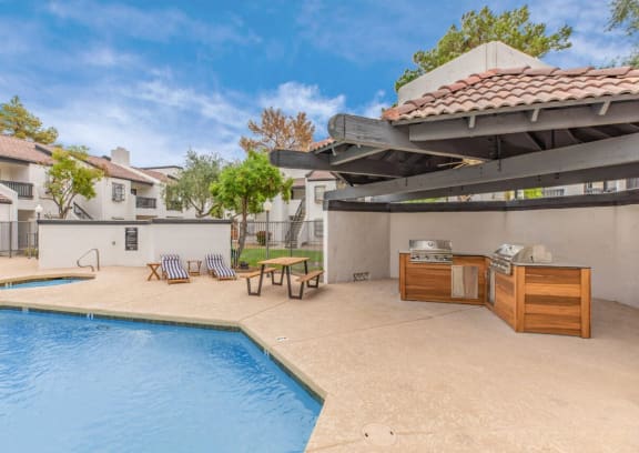 a patio with a grill and a swimming pool