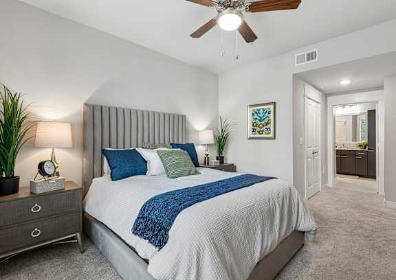 a bedroom with a bed and a ceiling fan