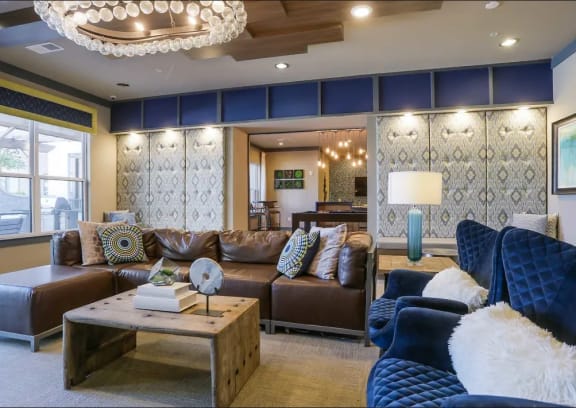 a large living room with blue and brown furniture and a chandelier