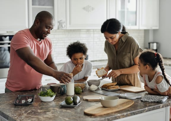 a family in the kitchen preparing a meal
