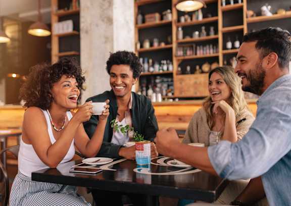 a group of people sitting at a table in a restaurant at The Knights @ 506 Delaware Apartments, Buffalo, NY